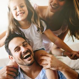 picture of young couple and their daughter laughing