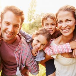 picture of a young family outside having fun and laughing